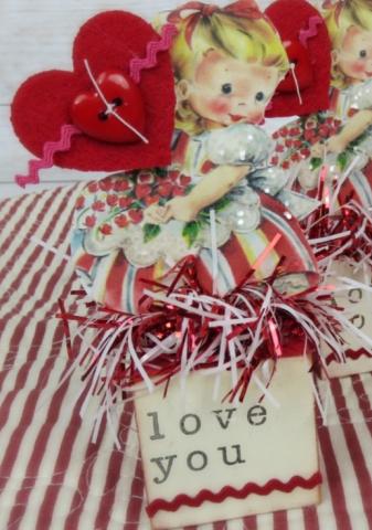 Valentines decoration, a little paper girl holding a large heart with a placard beneath her reading I love you