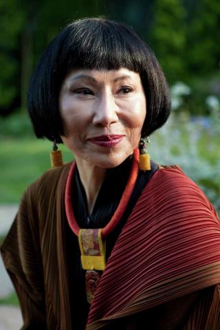 Portrait of a smiling woman with a short bob haircut, wearing a necklace and a shawl