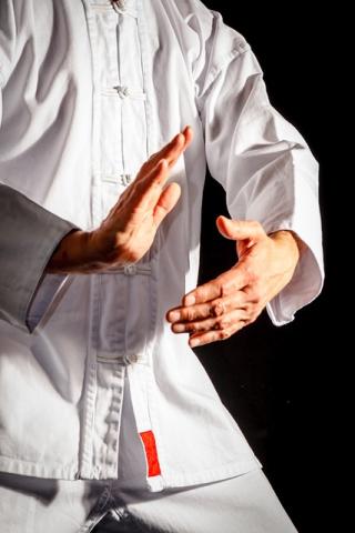 Photo of torso and hands in white robes doing a qigong movement