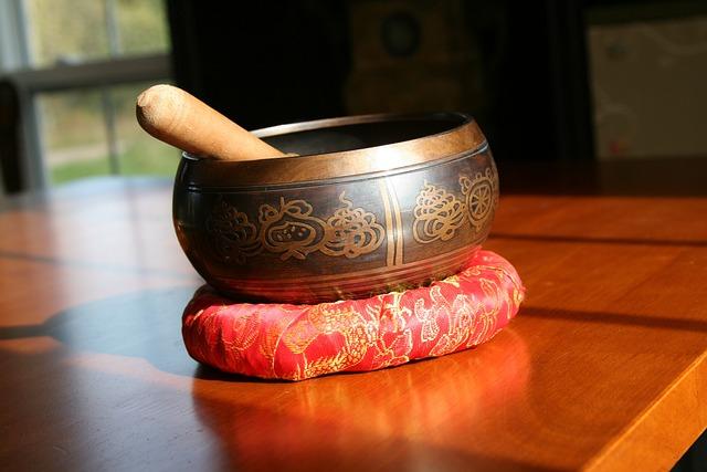 A Tibetan sound bowl on a cushion with a striking stick inside of it