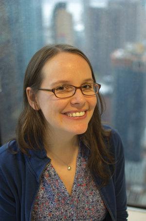 Smiling woman with glasses and long brown hair