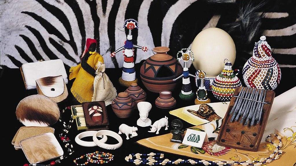 A table displaying a variety of traditional African instruments, jewelry, and art.